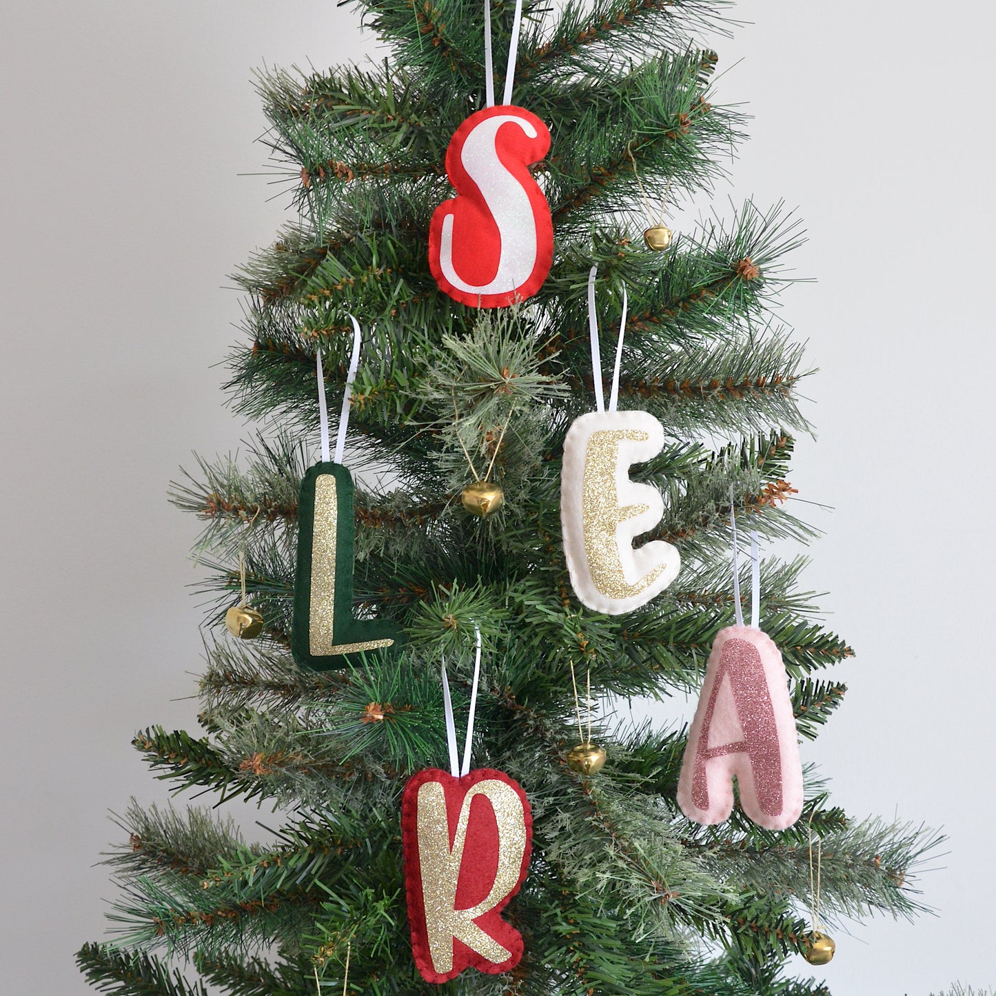 Handmade letter decorations on a Christmas Tree in various colours.