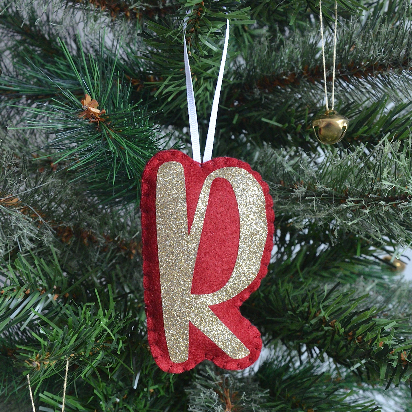 Personalised red and gold letter decoration on a Christmas tree