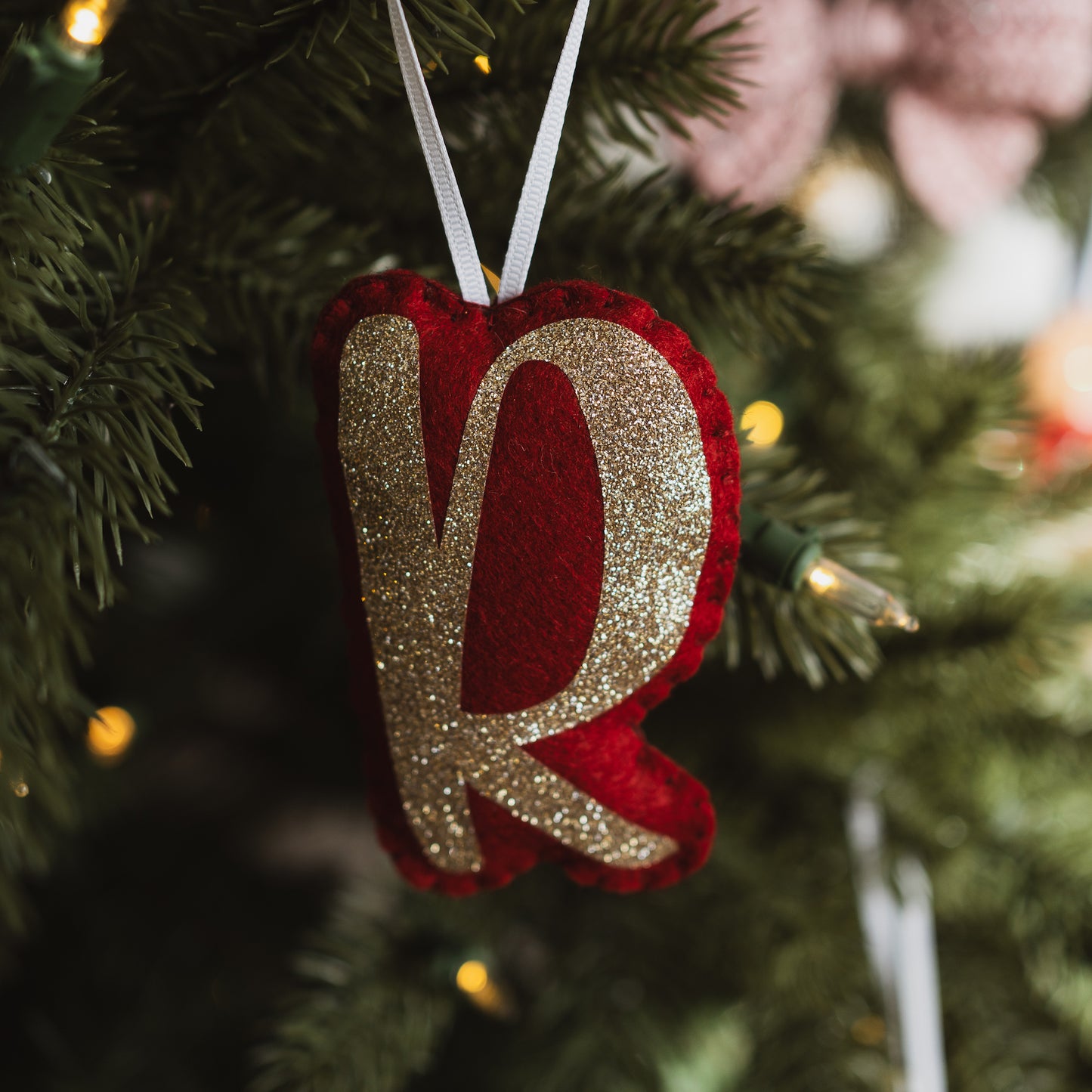 Personalised red and gold letter decoration on a Christmas tree
