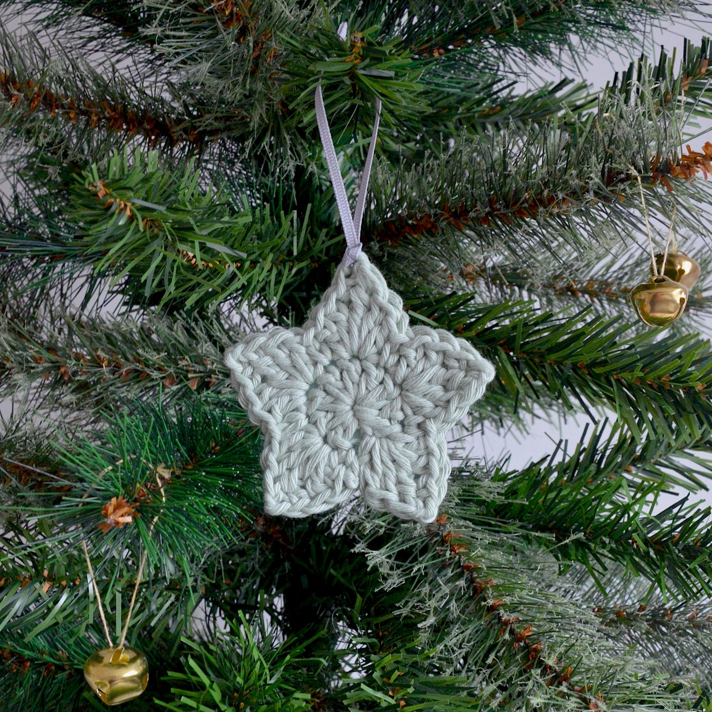 pale green crochet star decoration hanging on Christmas tree
