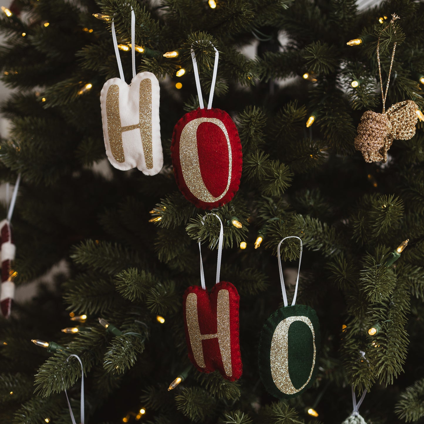Handmade letter decorations on a Christmas Tree in various colours.