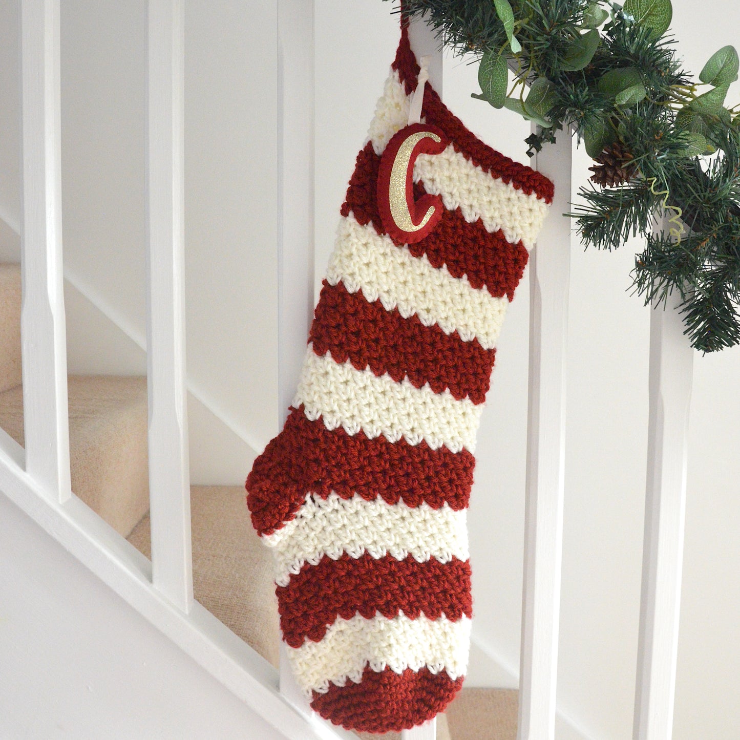 Red and white striped Christmas stocking hanging on a staircase