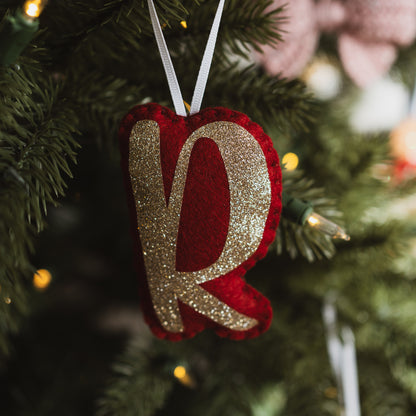 Personalised red and gold letter decoration on a Christmas tree