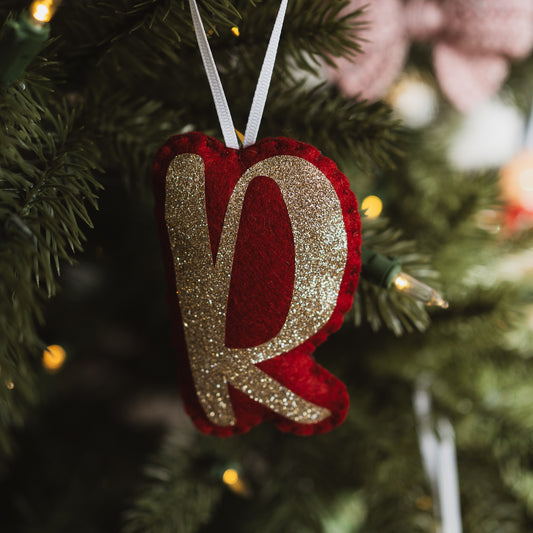 Personalised red and gold letter decoration on a Christmas tree