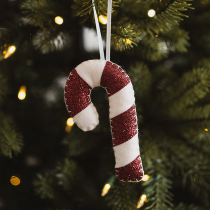 Red candy cane decoration hanging on a Christmas tree
