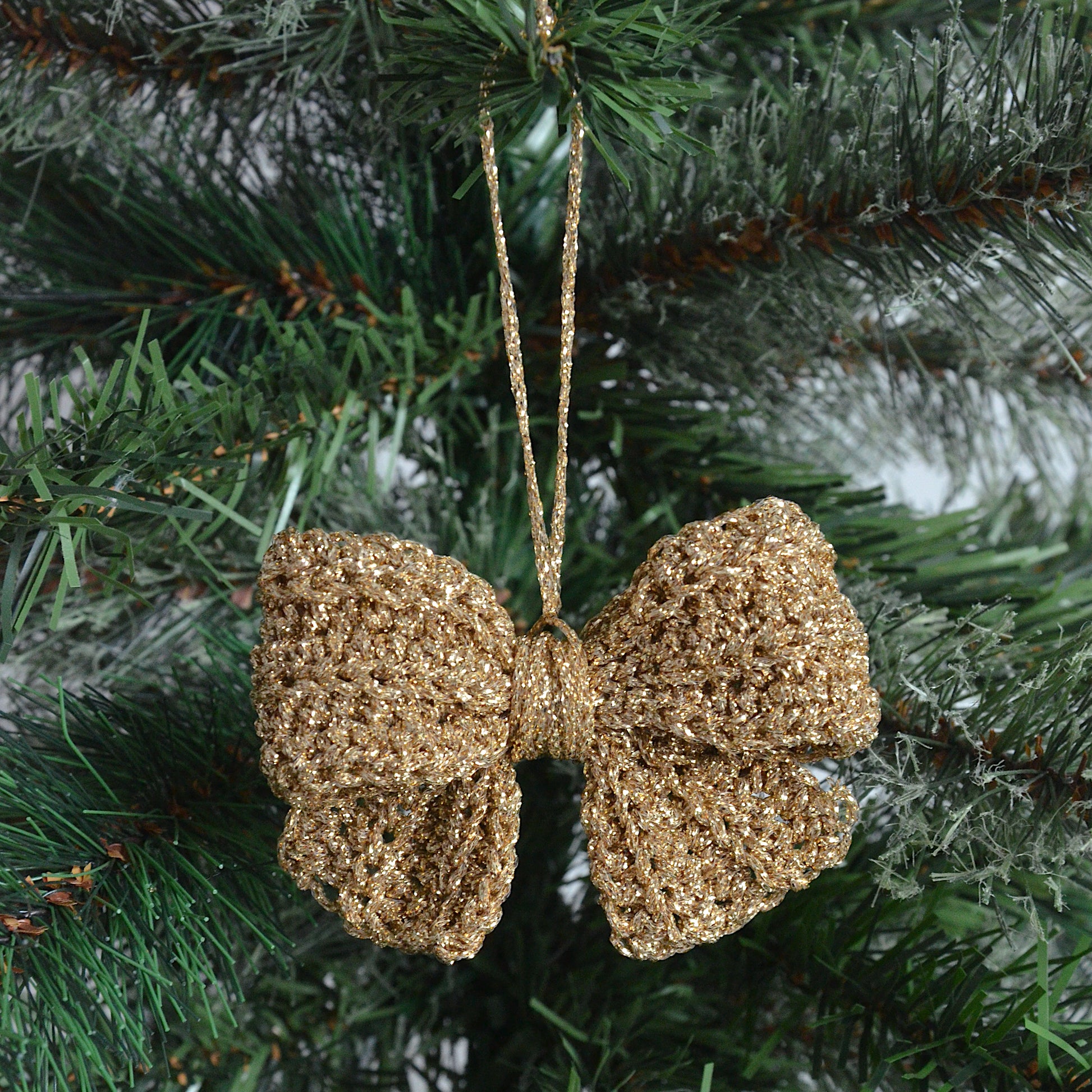 Gold crochet bow decoration hanging on a Christmas tree