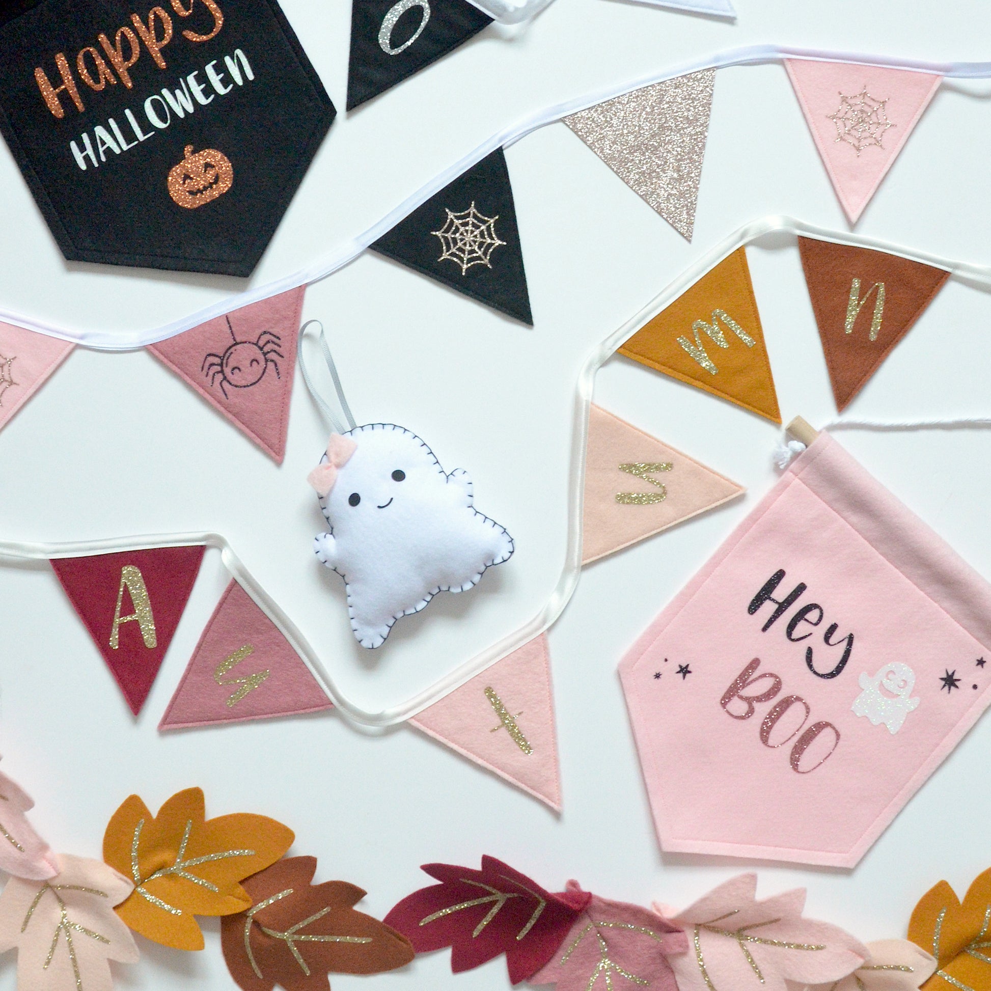 Halloween-themed autumn decorations including a ghost, bunting flags, and leaves on a white background.