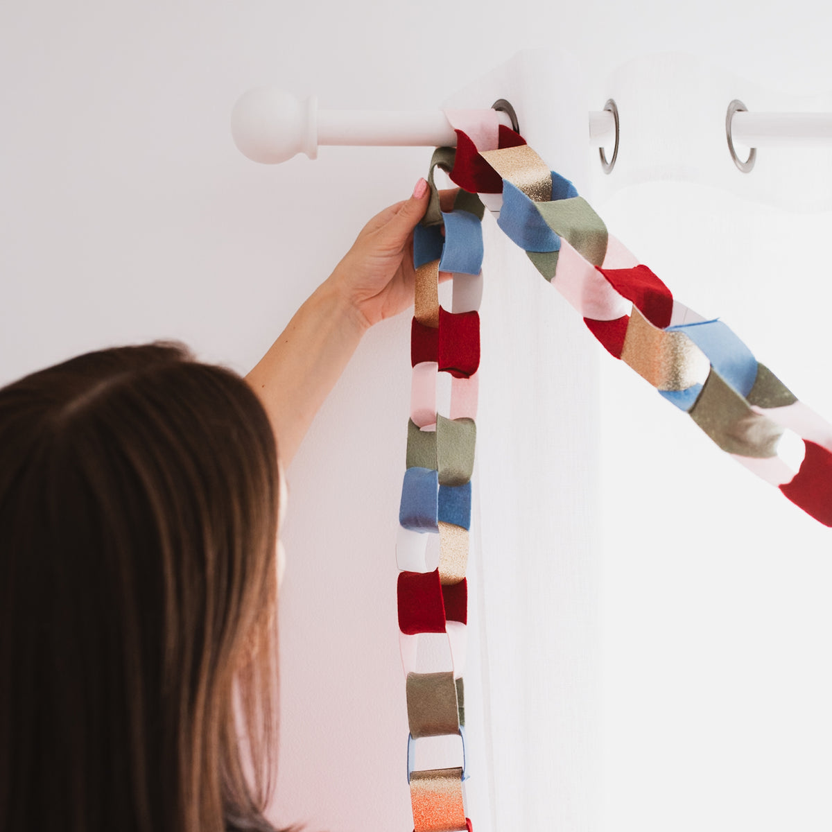 Handmade felt Christmas chain garland being hung as a festive decoration