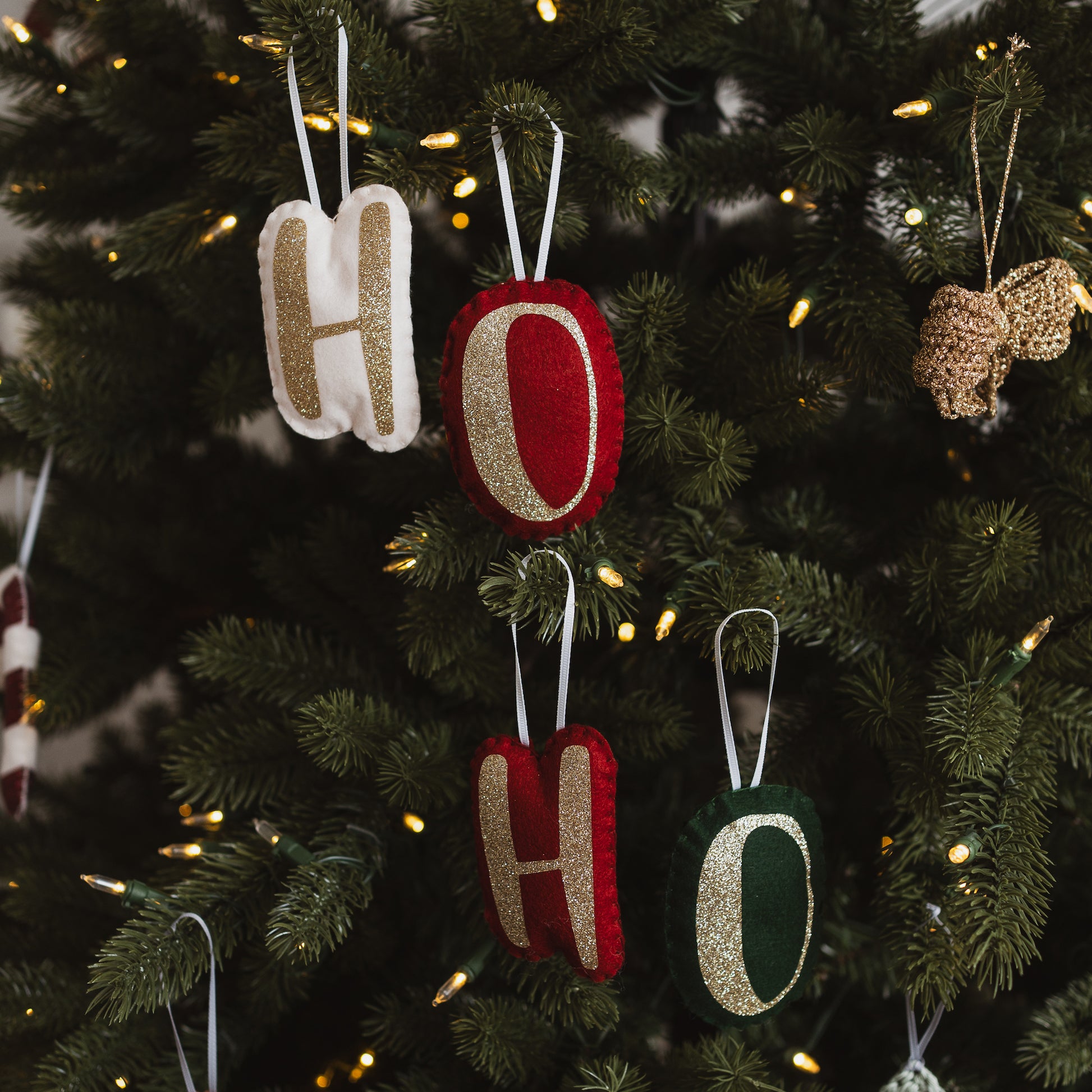 Handmade letter decorations on a Christmas Tree in various colours.