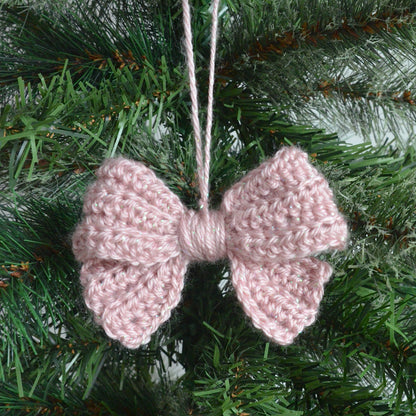 Pink crochet bow hanging on a Christmas tree