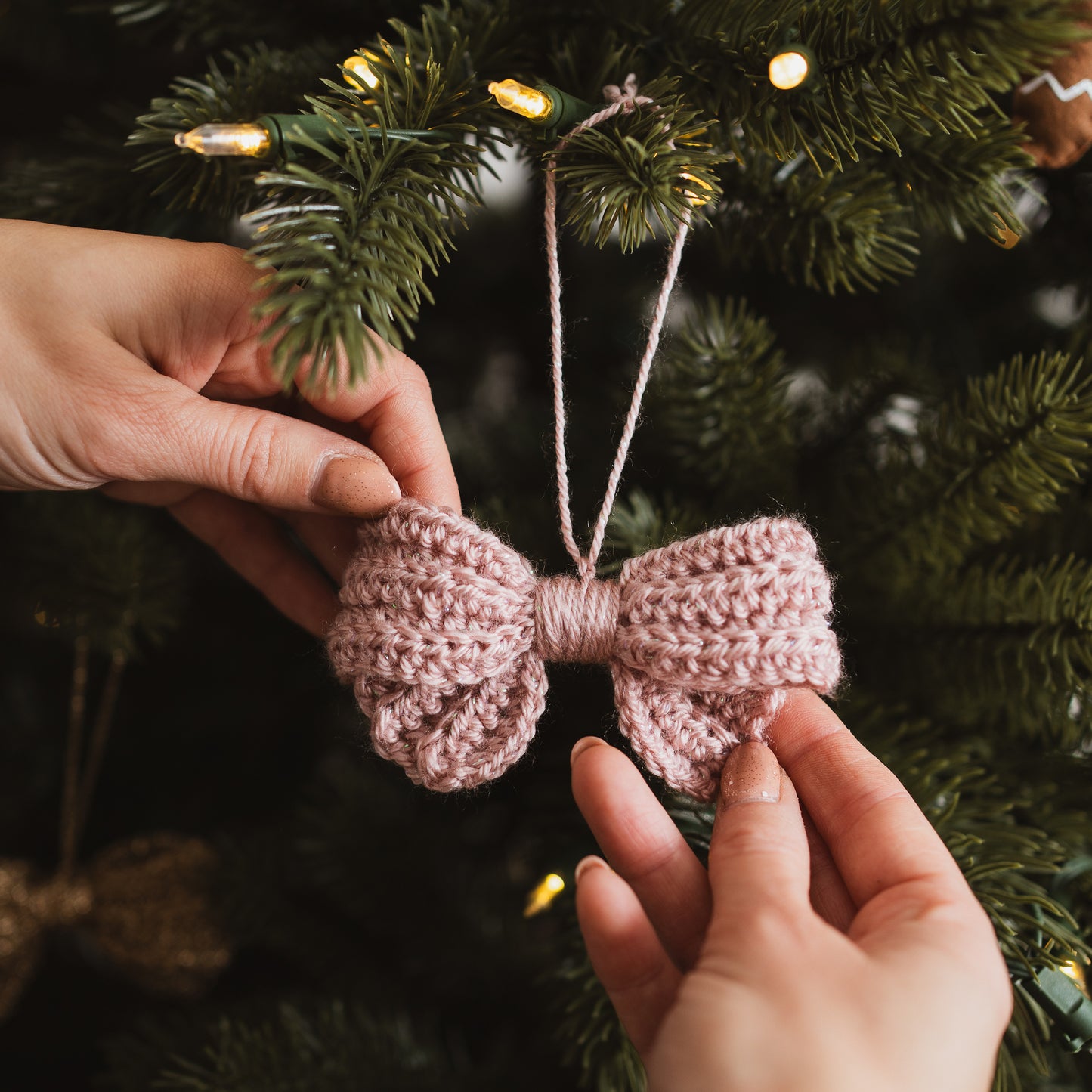 Pink crochet bow hanging on a Christmas tree
