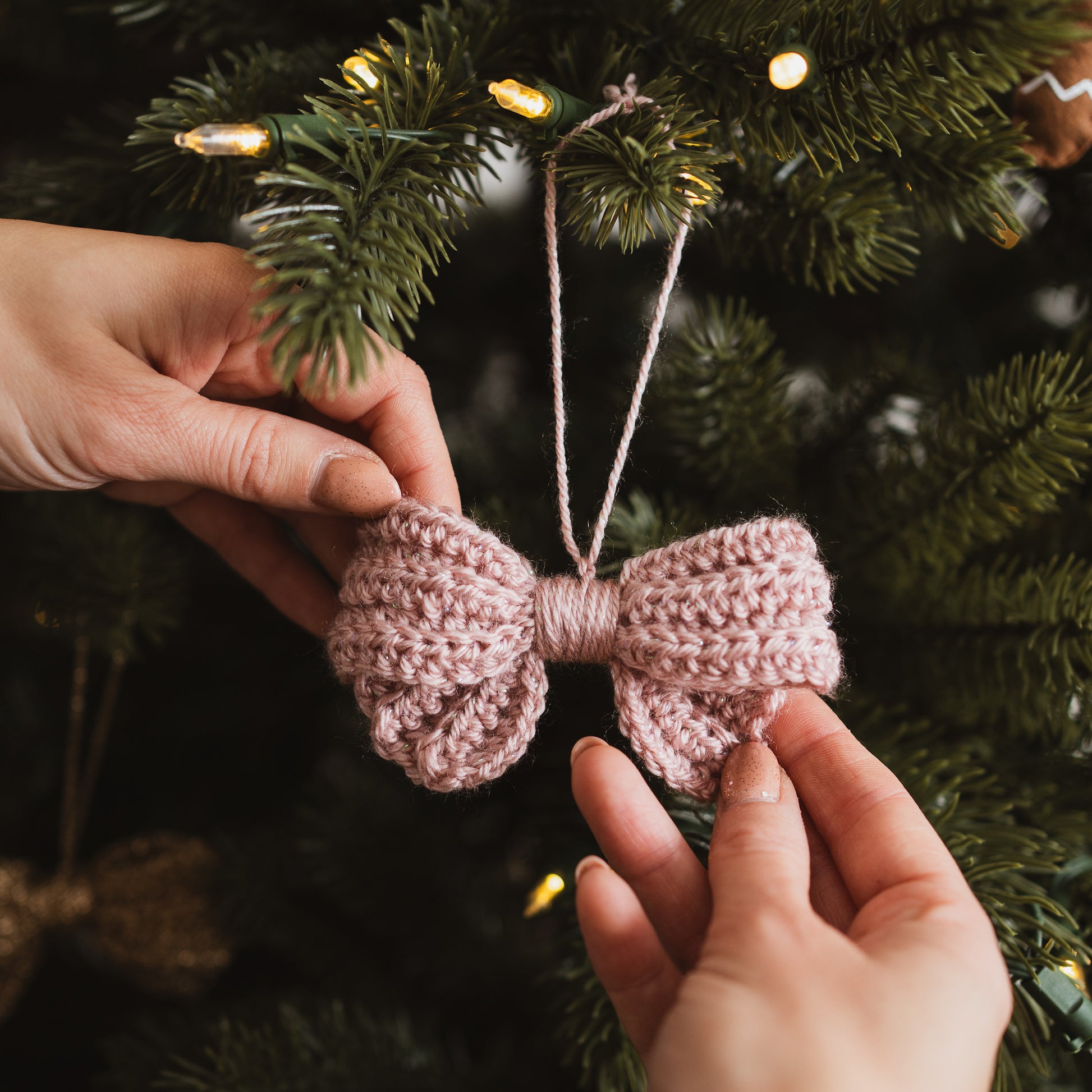 Pink crochet bow hanging on a Christmas tree