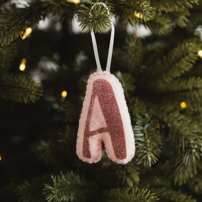 Pink initial decoration hanging on a Christmas tree